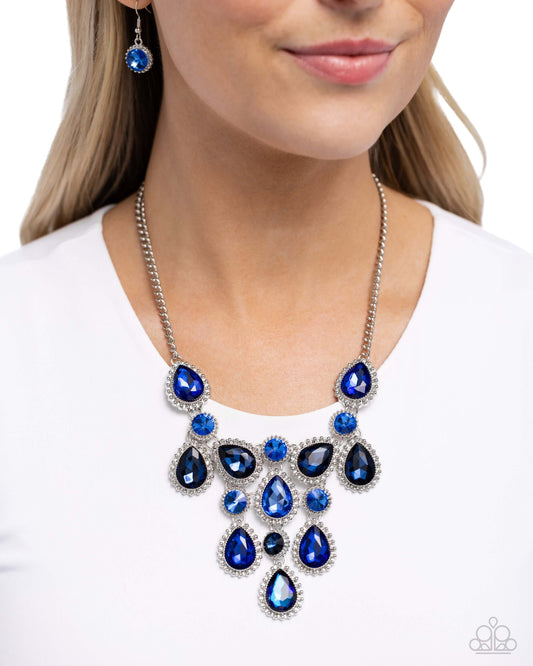 Dripping in Dazzle blue Paparazzi necklace with faceted gems and silver studs on model, showcasing teardrop and round cuts.