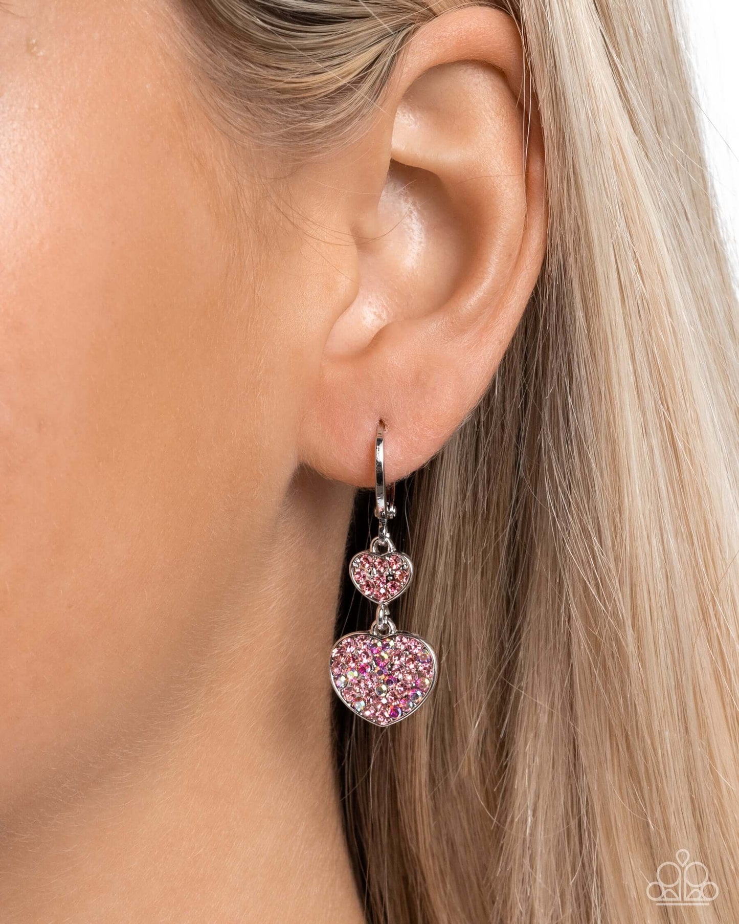 Pink Paparazzi heart earrings with rose rhinestones on model's ear for Valentines Day.